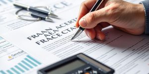 Une main tenant un stylo sur un contrat financier.